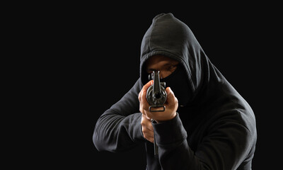 Hacker spy criminal man hands wearing a black shirt, standing on the floor is thief, holding gun,...
