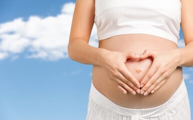 Young healthy happy woman made with hands a heart shape