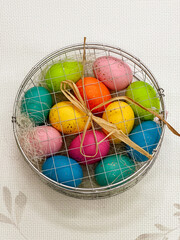 Colorful Easter eggs in a basket on a white background