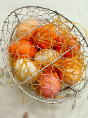 Colorful Easter eggs in a basket on a white background	
