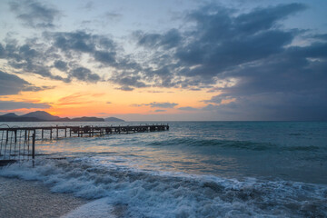 Wooden pier in sea at sunrise. Koktebel. Crimea