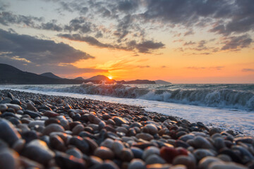 Obraz premium Sea coast with stones at sunrise. Beach of Black sea