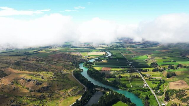 Freshwater Oasis Pinders Pond With Camping Area And Swimming Spot Surrounded By Trees Near Roxburgh In Central Otago, New Zealand. aerial pullback