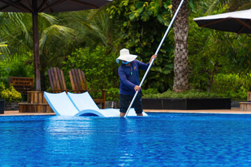 Fototapeta na wymiar A man is doing swimming pool cleaning service. Selective focus