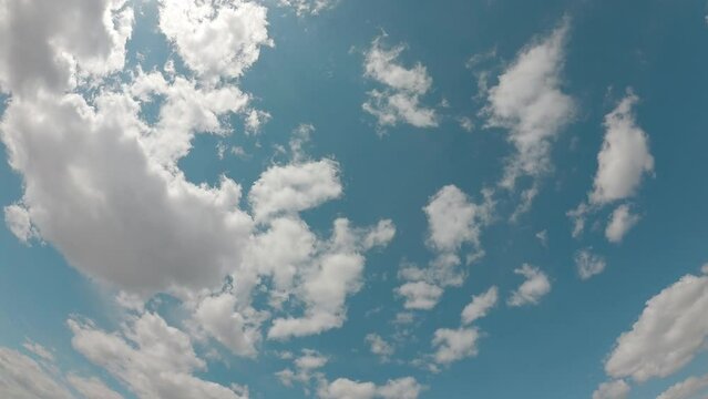 timelapse of clouds blue sky low angle view wide screen summer season white fluffy clouds in good weather over the sky. Look up view softness of nature heavenly clear blue sky background