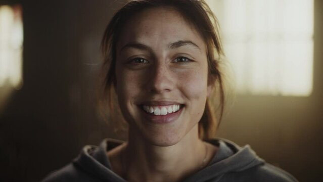 Close-up portrait of a beautiful caucasian athlete woman smiling looking at camera at gym