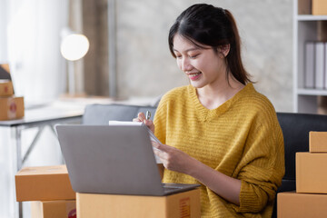 Portrait of Online business owner Asian female small businesses SME entrepreneur working at home, online marketing, packing boxes, SME sellers, concept, e-commerce team, online sales.