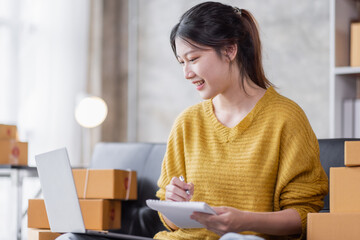 Portrait of Online business owner Asian female small businesses SME entrepreneur working at home, online marketing, packing boxes, SME sellers, concept, e-commerce team, online sales.