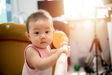 Cute little baby Standing in cradle at home, Asia baby in crib with windows light in home