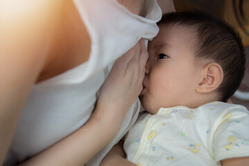 Fototapeta na wymiar Asia baby is happy at breast-feeding time, Asian mom breast feeding her baby boy