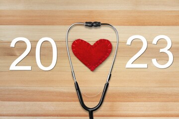 Stethoscope, red heart and 2023 numbers on background.