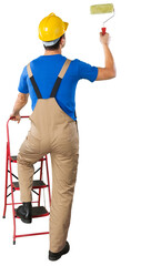 House painter is painting white wall, Back view from behind Young full length man in blue overalls...