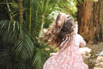 Preschool girl playing in pretty tropical kindergarten garden