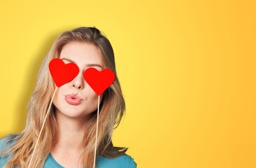 Blinded by love. Young woman holding heart-shaped paper