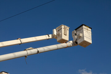 Manlift boom arms for utility work or trtee trimming against a blue sky