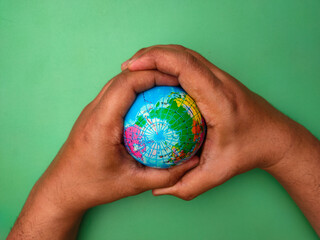 Hand holding earth globe on a green background