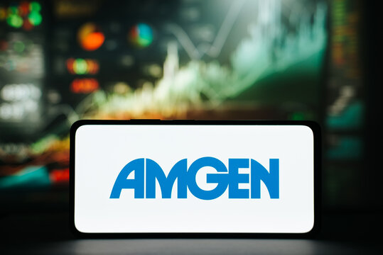 Amgen and investment, financial business concept. Amgen biotechnology company logo on screen of smartphone against background of stock chart trading view. Astana, Kazakhstan 20.02.2023