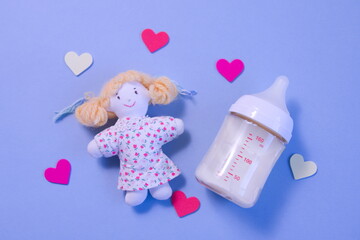 哺乳瓶と人形とハートの青背景の写真