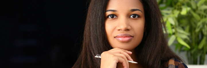 Thoughtful focused beautiful afro woman with pen