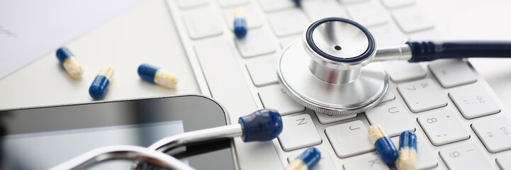 Tablets and stethoscope on computer keyboard closeup