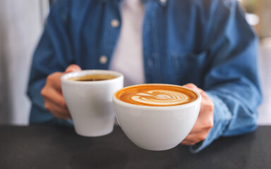 Closeup image of a woman holding and serving two cups of hot coffee