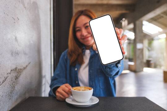 Mockup image of a beautiful woman showing a mobile phone with blank white screen