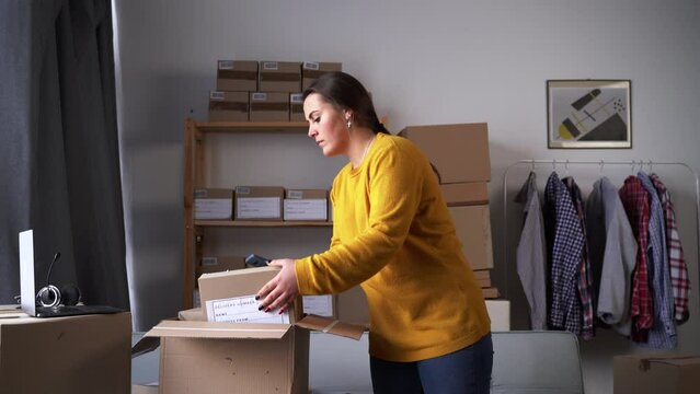Female small business owner using mobile app on smartphone checking parcel box. seller scanning retail drop-shipping package postal parcel barcode.Preparing post courier delivery package.