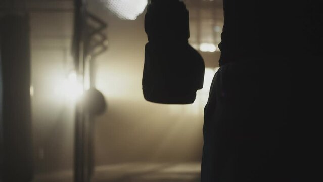 Unrecognizable male boxer wearing boxing gloves walking to the practice ground for practice in slow-motion