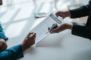 give a car keys, A car dealer or sales manager offers to sell a car and explains the terms of signing a car and insurance contract.