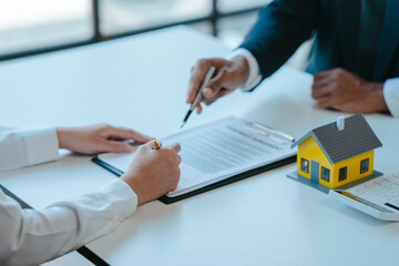 Suggestion to sign a contract, realtor suggestion a new house model assisting client to sign contract agreement with insurance to happy living building, concerning mortgage loan offer