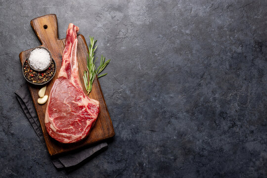 Raw Tomahawk beef steak and spices