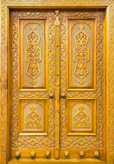 Fototapeta na wymiar Carved wooden doors with patterns and mosaics. Abstract background.