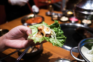 Korean grilled pork with vegetable wrap korean style, Korean barbeque dish, served with fresh lettuce Traditional korean food.