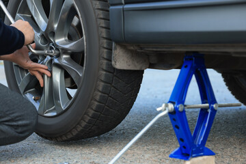 Man changing tire of car outdoors, closeup