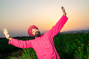 Punjabi sikh man doing bhangra dance in agriculture field celebrating Baisakhi or vaisakhi festival.