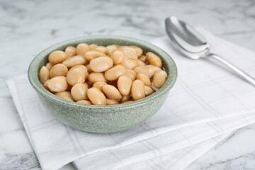 Bowl of canned kidney beans on white marble table, closeup