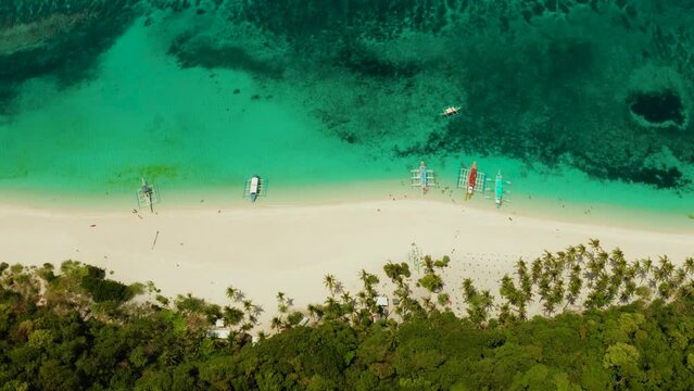 Tropical white sand beach, near the blue lagoon and corall reef from above, Boracay, Philippines. Sandy beach with tourists. Summer and travel vacation concept.
