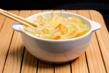 Saute grated young papaya with steam from wooden chopsticks. hot food concept