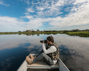 Turista fotografando animais em passeio de barco no no Pantanal de Barão de Melgaço, Mato Grosso