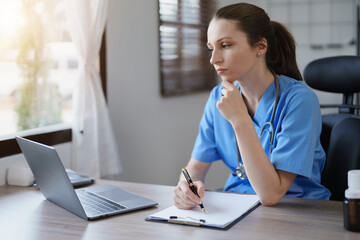 Portrait of female doctor holding patient diagnosis papers.