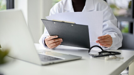 Cropped image of a professional female doctor in uniform working at her desk in the office