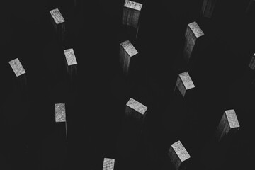 black and white abstract of wooden blocks standing in the dark sky. hike of everything
