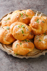 Homemade hot fresh Garlic Knots buns closeup on the plate on the table. Vertical