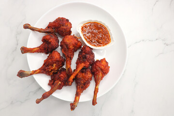 Chicken lollipop is an Indian style of Chinese appetizer. surved with schezwan chutney. Over white...