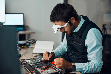Technician, computer and engineer repair motherboard, microcircuit or electronic device in a workshop or shop. Person, man and guy fixing hardware with electric meter for technology in a lab