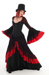 portrait of beautiful red haired woman wearing long black fantasy vampire costume gown, isolated pose on  studio background.