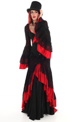 portrait of beautiful red haired woman wearing long black fantasy vampire costume gown, isolated pose on  studio background.