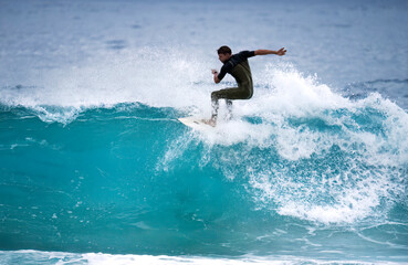 Professional surfer riding ocean waves On banzai pipeline north shore Oahu Hawaii. Surfing a large sea wave on short surfboard in the summer sun.