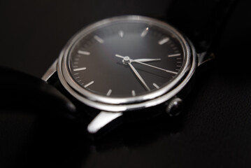 Quartz wristwatch with black dial close-up
