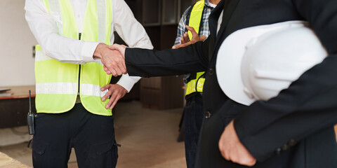 Civil Construction team Handshake at renovate construction site. architectural plan, engineer sketching a construction project, green energy concept.